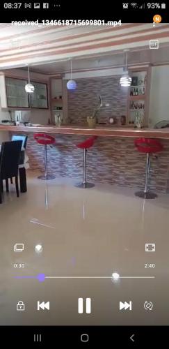 a bar with red stools in front of a counter at Bon Joy Bed & Breakfast in Mabini