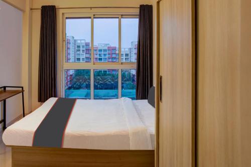 a bedroom with a bed and a large window at Flagship Santoshi Holiday Home in Dabolim