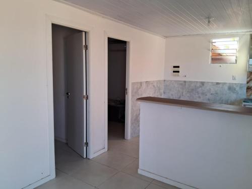uma cozinha com paredes brancas e um balcão em Aeroclube em Salvador