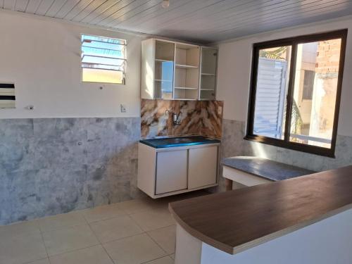 uma cozinha com um balcão, um lavatório e uma janela em Aeroclube em Salvador
