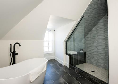 a bathroom with a large tub and a glass shower at The August House in Windsor