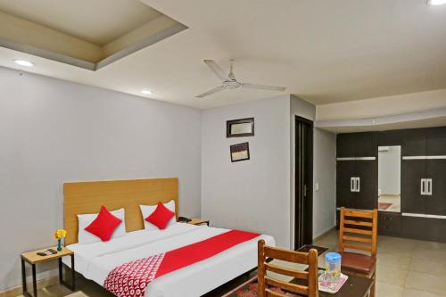 um quarto com uma cama, uma mesa e cadeiras em OYO Flagship Red Stay Near V3S Mall em Nova Deli