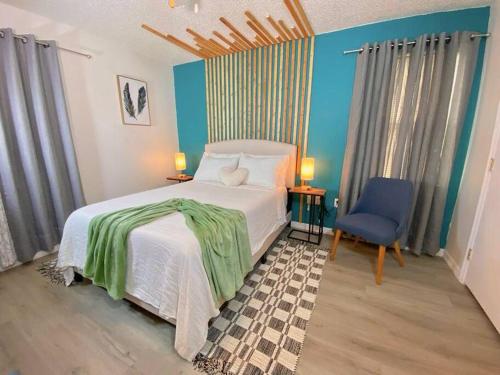 een slaapkamer met een wit bed en een blauwe stoel bij Private Retreat: Pool, king bed , Comfy Furnishings in Gainesville