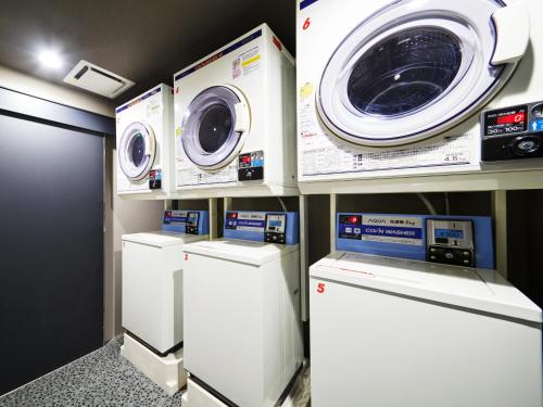 a laundry room with three washing machines and a washer and dryer at MIMARU Osaka Namba North in Osaka