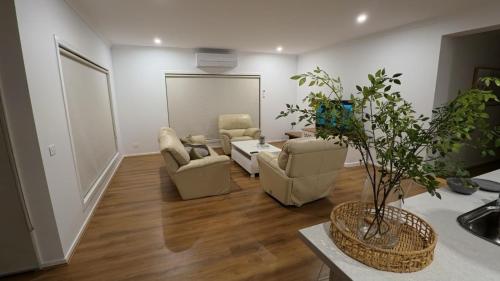 a living room with a couch and chairs and a table at Brand New House in Lakes Entrance in Lakes Entrance