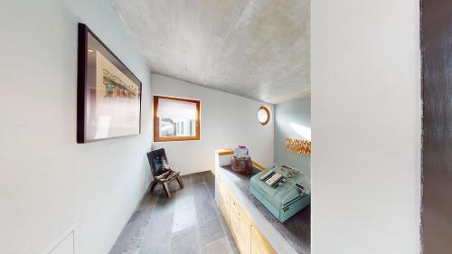 a room with a hallway with white walls and a table at Abitaziun Maira - Maloja in Maloja