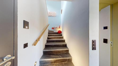 a staircase in a house with white walls and wooden floors at Abitaziun Maira - Maloja in Maloja