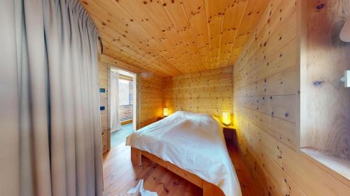 1 dormitorio con 1 cama en una habitación de madera en Abitaziun Maira - Maloja, en Maloja