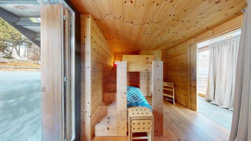 a wooden cabin with a bed and a window at Abitaziun Maira - Maloja in Maloja