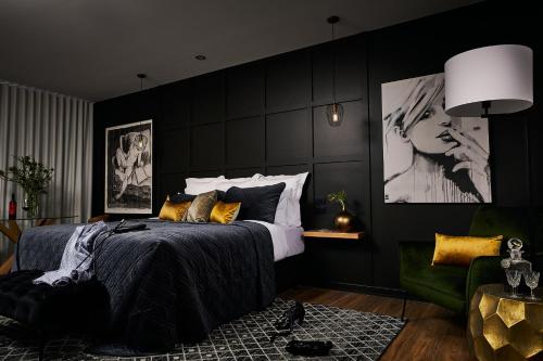 um quarto com paredes pretas e uma cama com almofadas amarelas em Lancefield Luxury Guest Suite - DoubleDare em Lance Field