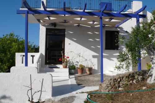 a house with a blue pergola on the porch at Stefanos Garden in Arménoi