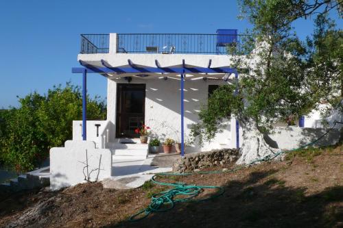 a house with a blue awning on the side of it at Stefanos Garden in Arménoi