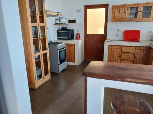 a small kitchen with a stove and a microwave at Casa de Playa Akas in Canoas de Punta Sal