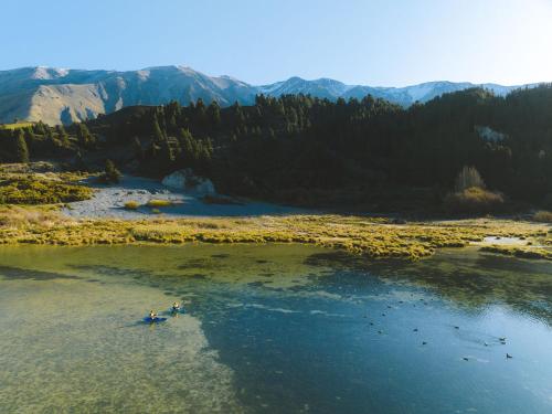 two people kayaking on a river in the mountains at Montrose Estate in Mount Hutt