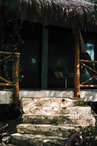 a building with a grass roof and some stairs at Villas Zamna - Jungle Villas in Cozumel