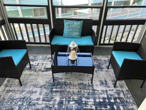 a balcony with two chairs and a table on a balcony at Ocean Breeze Beachfront Condo, Newly Renovated in Myrtle Beach