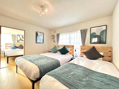 富良野的住宿－FURANO BnB，酒店客房,设有两张床和镜子