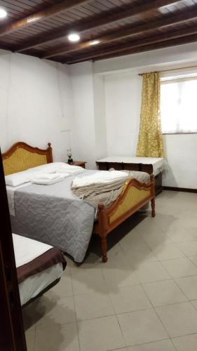 1 dormitorio con 2 camas y ventana en O Recanto do Sobreiro, en Vale de Porco