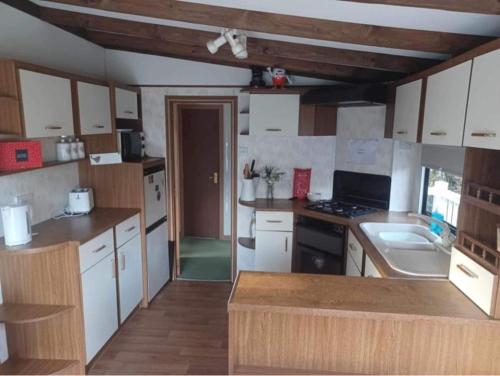 a kitchen with white cabinets and a counter top at Beautiful Scenic Holiday Chalet in Lincolnshire