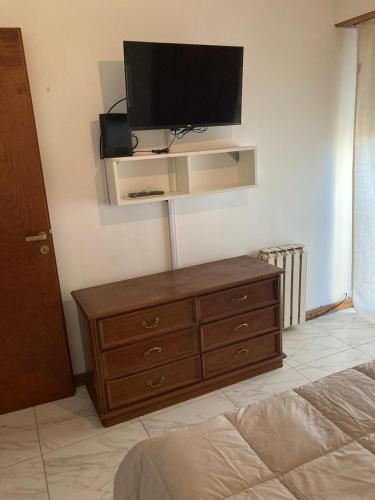 a bedroom with a dresser with a television on a wall at Depto Mitre 578 in Tandil
