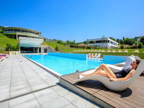 a woman laying on a lounge chair next to a pool at Blau Gran Hotel Las Caldas - Adults Only in Las Caldas
