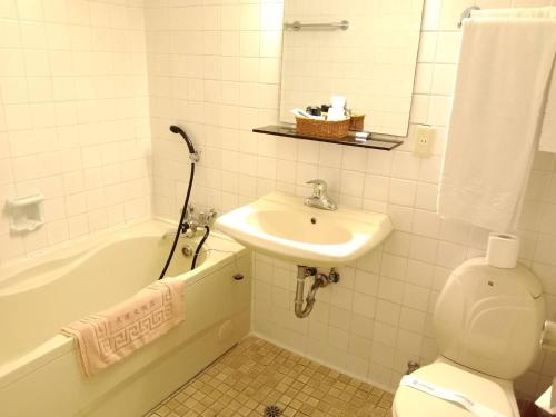 台北的住宿－天津大飯店 ，浴室配有盥洗盆、卫生间和浴缸。