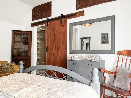 a bedroom with a mirror and a dresser at Smithy Apartment in Matlock