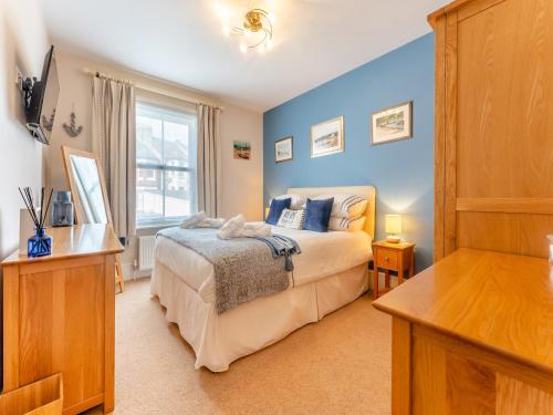 a bedroom with blue walls and a bed and a window at Casa Musica in Broadstairs