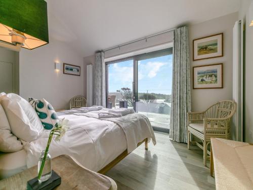 a bedroom with a bed and a large window at Long Commons in Saint Mawes