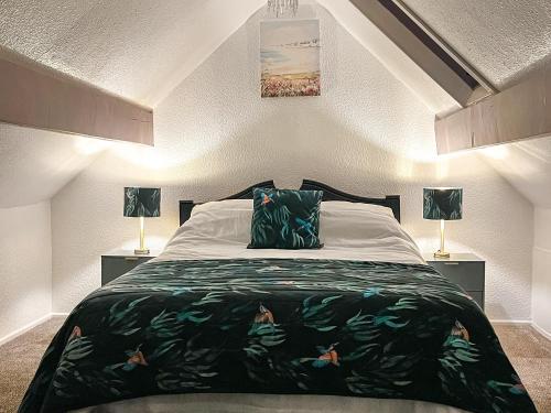 a bedroom with a large bed and two lamps at Cart Cottage - 28343 in Staintondale