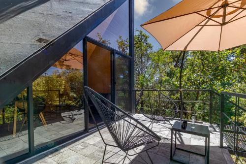a patio with a chair and an umbrella at Grasshopper Cabañas in Cuautla Morelos