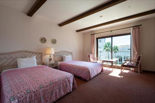 um quarto de hotel com duas camas e uma varanda em Hotel Shima Spain Mura em Shima