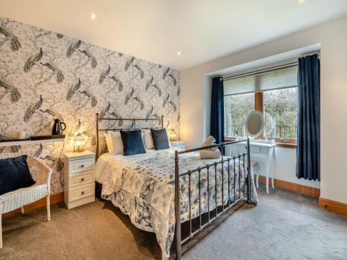 a bedroom with a bed and a desk and a window at Cairn View - S4402 in Aviemore