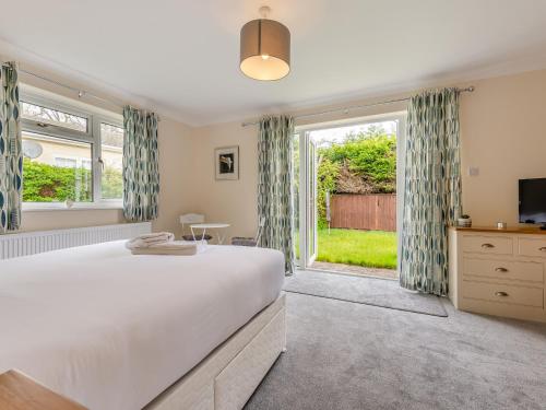 a bedroom with a large bed and a large window at Little Hill Farm Villa in Ringwood