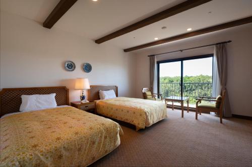 a hotel room with two beds and a large window at Hotel Shima Spain Mura in Shima