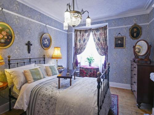 a bedroom with a bed with blue wallpaper at St Marys Chambers in Mold