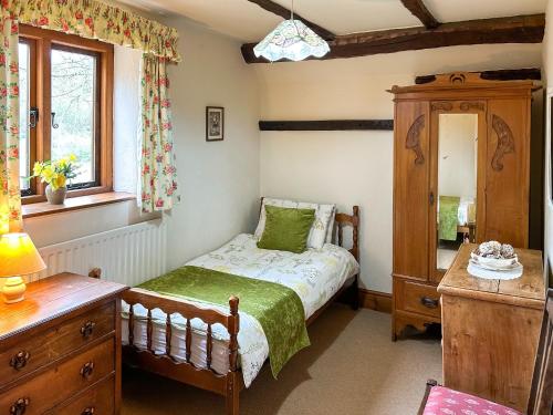 a small bedroom with a bed and a dresser at Millstone Cottage - Uk46676 in Highley