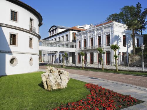 a large white building with a large rock in the yard at Blau Gran Hotel Las Caldas - Adults Only in Las Caldas