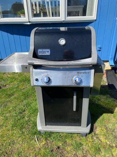 a stove sitting in the grass next to a house at Lake Attitash Waterfront w/ private dock in Amesbury