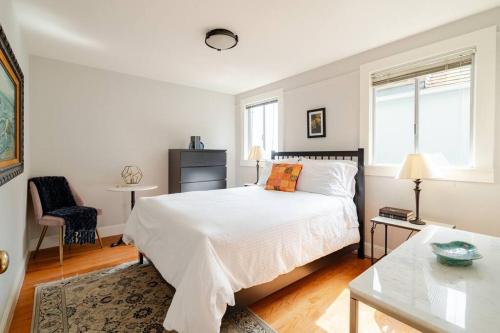 - une chambre blanche avec un lit et une table dans l'établissement Dreamy 3-Story House : Sunroom + City Skyline View, à San Francisco