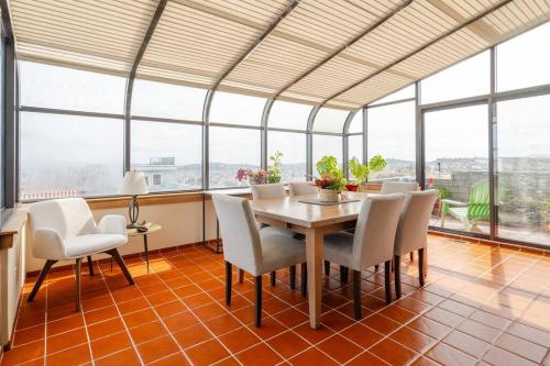 a dining room with a table and chairs and windows at Dreamy 3-Story House : Sunroom + City Skyline View in San Francisco