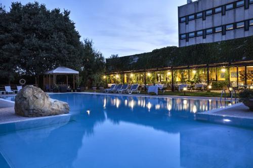 una piscina di fronte a un edificio di notte di Hotel Saccardi & Spa - Adults Only a Caselle di Sommacampagna