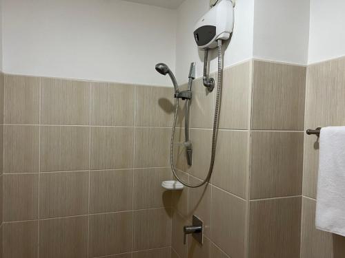 a shower with a shower head in a bathroom at Grand Riviera Suites in Manila