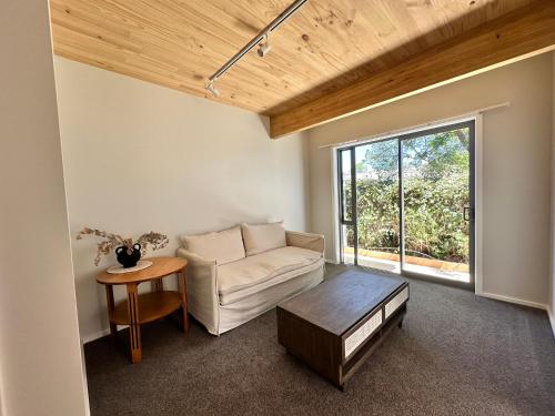 ein Wohnzimmer mit einem Sofa und einem Tisch in der Unterkunft Stylish 3-bed Taradale Townhouse in Napier