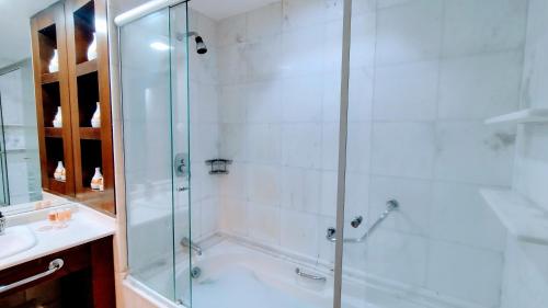 y baño con ducha y puerta de cristal. en Hotel M-RCURE - Av Paulista - GRAND PLAZA - Deluxe king Studio Veranda - BATH SPA - Executive Class - By LuXXoR en São Paulo