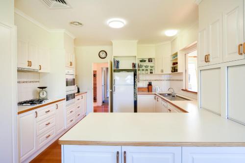 a kitchen with white cabinets and a refrigerator at Monymusk in Flinders