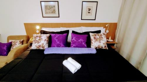 a bedroom with a bed with purple pillows at Hotel M-RCURE - Av Paulista - GRAND PLAZA - Deluxe king Studio Veranda - BATH SPA - Executive Class - By LuXXoR in São Paulo