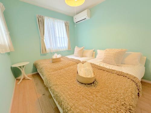 sypialnia z 2 łóżkami i oknem w obiekcie グランディオーソ沖縄ヴィラ恩納2 w mieście Onna