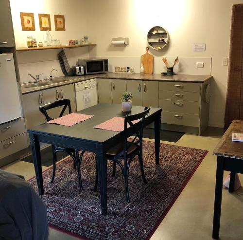 a kitchen with a table and chairs in a kitchen at Cosy Country Stay B&B in Matamata