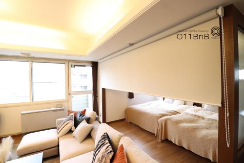 a bedroom with a large bed and a couch at NK BLD8F Sapporo 3LDK 3BR 1 floor 1 room in Sapporo